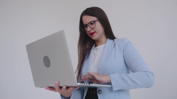 Succesvolle jonge zakenvrouw die werkt aan een laptop die fronst en haar wenkbrauwen verrast. Emotie expressie concept — Stockvideo