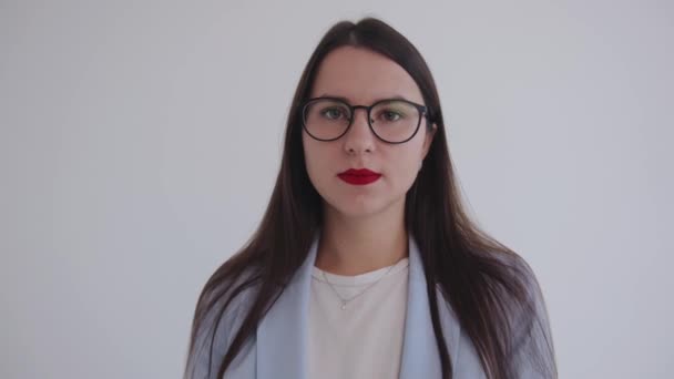 Retrato de una dama de negocios confiada y seria en gafas sobre un fondo blanco aislado. Feminismo. Poder de mujer — Vídeos de Stock