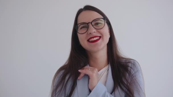 Gözlüklü, beyaz izole bir arka planda, gülen genç bir iş kadınının portresi. Kariyer ve başarı kavramı — Stok video