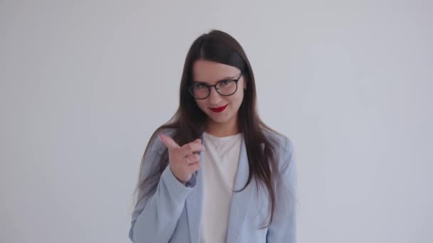 Eine schöne junge Geschäftsfrau mit Brille droht mit einem Zeigefinger, der ihre Augen verengt und ansteckend lacht — Stockvideo