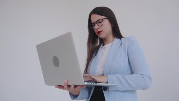 Uma bela jovem empresária está zangada com o laptop ocioso e bate a tampa. Emoções humanas. Feminismo. Poder da mulher — Vídeo de Stock