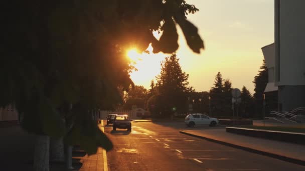Minsk, Biélorussie - 29 juin 2021 : Route avec des voitures dans le pâté de maisons à côté de la place et des bâtiments résidentiels au coucher du soleil. Mouvement lent — Video