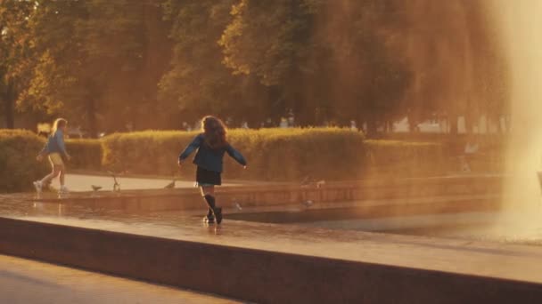 Minsk, Belarus - 29 Haziran 2021: Çocuklar su birikintilerine atlayıp bir yaz akşamı çeşmenin altında güvercinleri kovalıyorlar. Yavaş çekim — Stok video