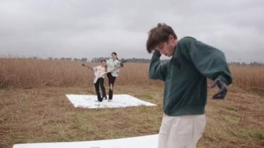 Genç bir insan ellerini siyah boyaya bulayıp doğada dans ediyor ve tuvallere resim çiziyor. Depresyon ve endişe kavramı