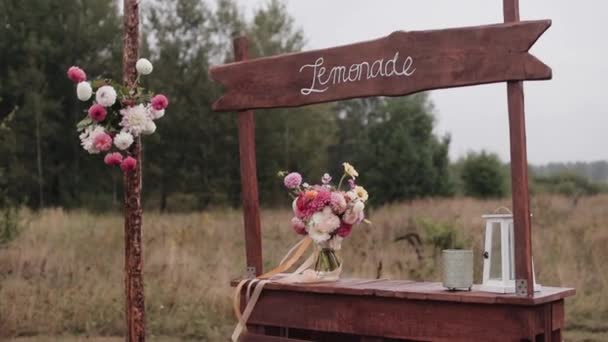 Cremagliera di legno per limonata a un matrimonio in natura decorato con mazzi di dalie e fiori di campo — Video Stock