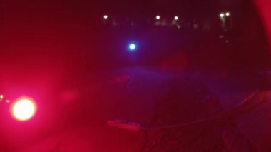 Beton zeminde kırmızı ve mavi ışıklar ve terk edilmiş büyük bir hangardaki metal yapılar.