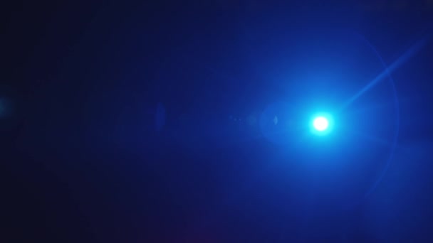 Hosszú fénysugár kék reflektorfényben a sötétben, fénymásoló felülettel és glóriaeffektussal, egyik oldalról a másikra fordul. — Stock videók