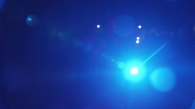 Bir grup genç, spot ışıkları ve el fenerlerinin uzun mavi ışıklarıyla alkışlıyor.