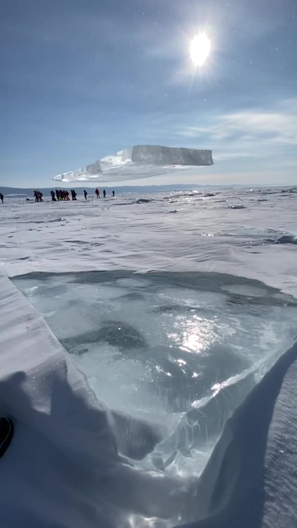 Un pedazo de hielo cristalino se aplasta contra un bloque en el congelado lago Baikal y se desmorona en pequeños fragmentos. Vista vertical. Movimiento lento — Vídeo de stock