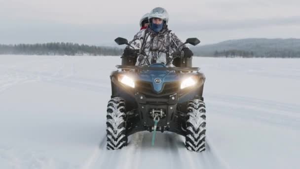 Murmansk bölgesi, Rusya - 10 Ocak 2021: Kasklı bir çift karlı bir arazide bisiklet sürüyor. Ön manzara. Yavaş çekim — Stok video