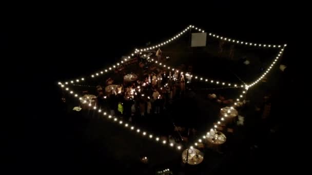 ベラルーシのミンスク- 2021年6月29日:夏の夜に輝くガーランドで飾られたオープンエリアでの結婚式パーティーの空中ビュー — ストック動画