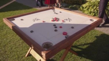 Minsk, Belarus - 14 Haziran 2021: Kulübenin avlusunda aktif tatilde olan bir grup insan ve erkekler bir çeşit bilardo oyunu oynuyorlar.