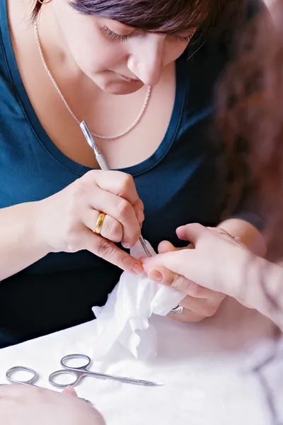 Closeup of a manicurist filing a female's nails — Stock Photo, Image