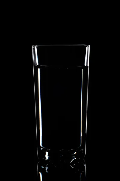 Woda w szkło na białym tle na czarnym tle — Zdjęcie stockowe