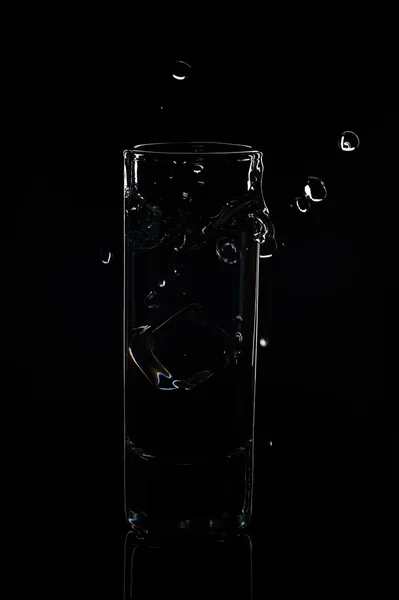 Vaso de agua y hielo sobre fondo negro — Foto de Stock