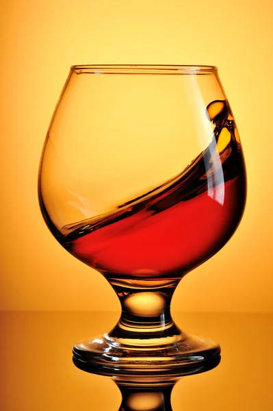 Glas cognac på gul bakgrund — Stockfoto