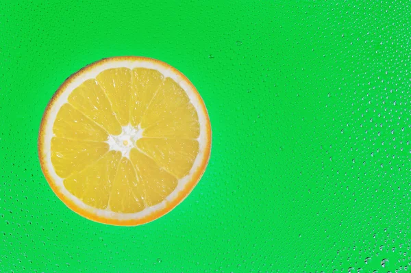 Rebanada de naranja sobre fondo verde —  Fotos de Stock