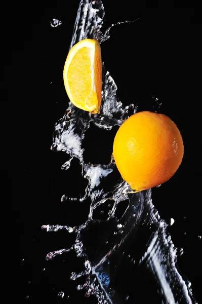 Naranja con salpicadura de agua sobre fondo negro —  Fotos de Stock