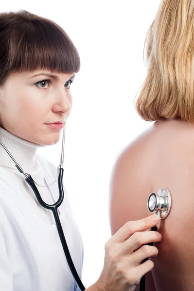 Doctor examining lungs of a female patient with stethoscope — Stock Photo, Image