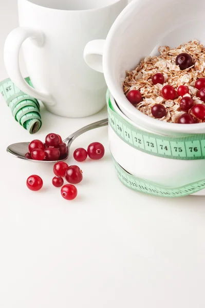 Flakes with cranberries on the white bowl and measure tape — Stock Photo, Image