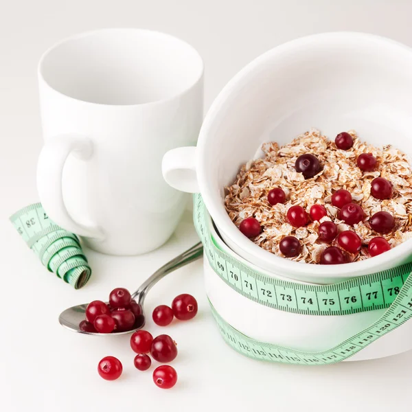 Flakes with cranberries on the white bowl and measure tape — Stock Photo, Image