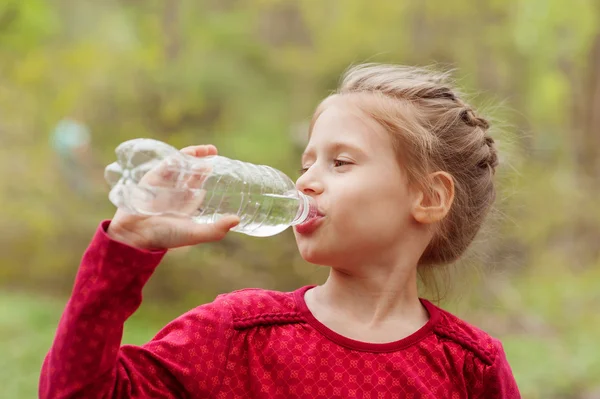 女の子はボトルから水を飲む — ストック写真