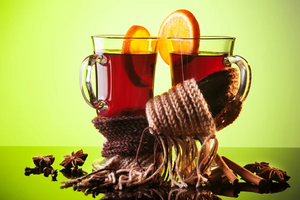 Mulled wine in two glasses and scarf on green — Stock Photo, Image