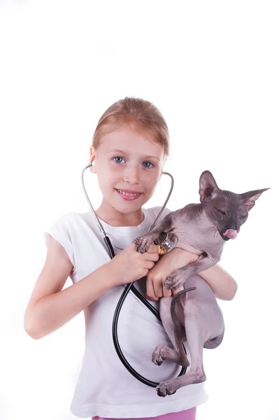 Flicka som leker en veterinär med katten shpinx — Stockfoto