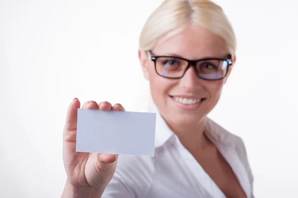 A beautiful woman in glasses holds out a business or credit card — Stock Photo, Image