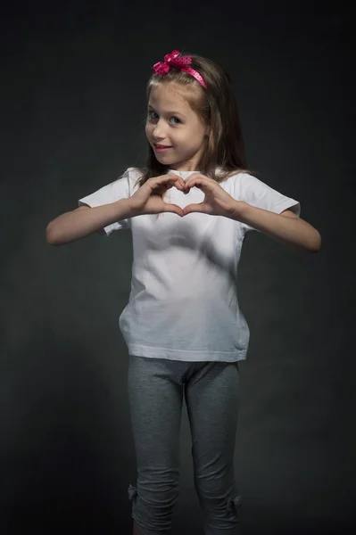 Nettes Mädchen zeigt herzförmiges Zeichen — Stockfoto