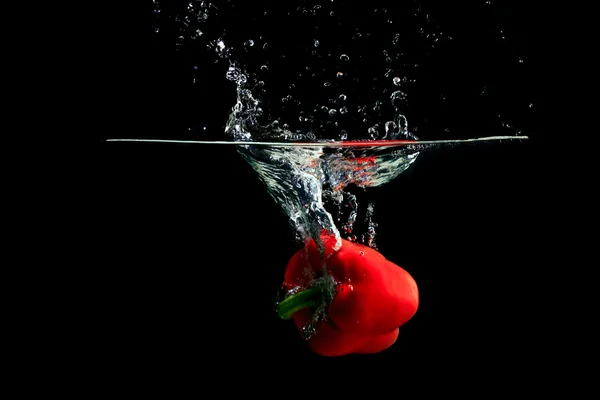 Röd paprika stänkande vatten — Stockfoto