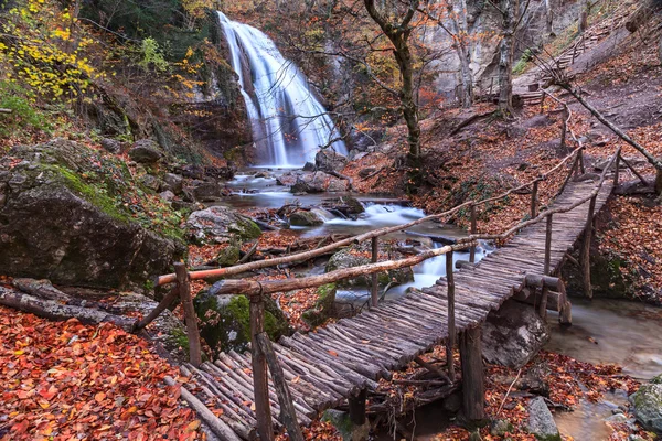 Herbst-Wasserfall mit Brücke lizenzfreie Stockfotos