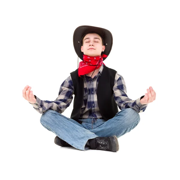 Junger schöner Mann mit Cowboyhut meditiert — Stockfoto