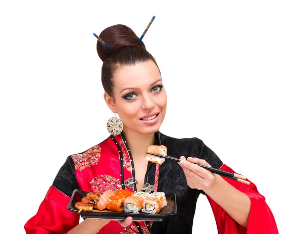 Mujer con un vestido rojo tradicional comiendo sushi — Foto de Stock