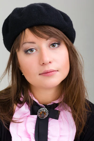 Молода модель в капелюсі на сірому фоні — стокове фото