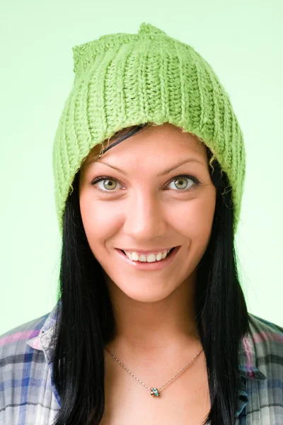 Mulher sorridente em um gorro verde em verde — Fotografia de Stock
