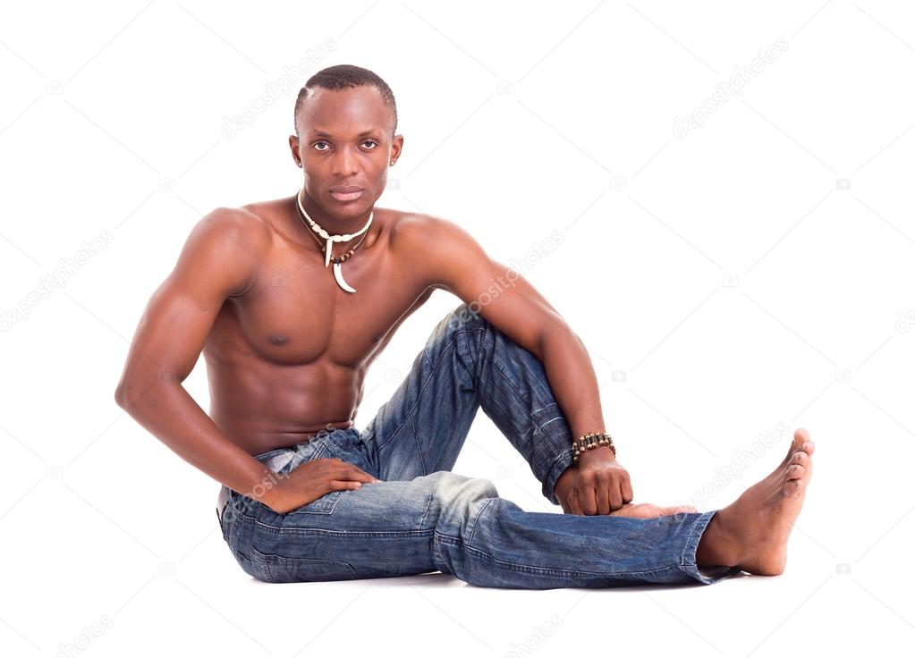 Young man wearing only jeans and sitting