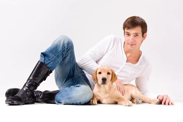 Handsome man with dog over gray — Stock Photo, Image