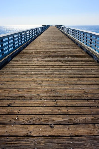 Long wooden Pier before blue sky — Stock Photo, Image