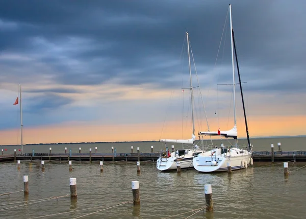 Stormy sunset with two yachts in marina — Stock Photo, Image