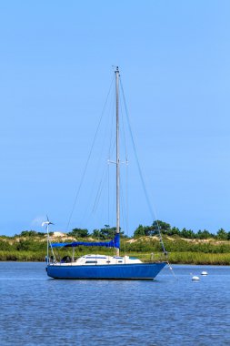 Sailing boat anchoring near beach coastline