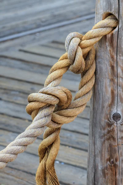 Верёвка и узел, привязанные к деревянному столбу — стоковое фото