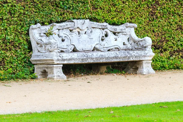 Jardín inglés ornamental con banco de piedra — Foto de Stock