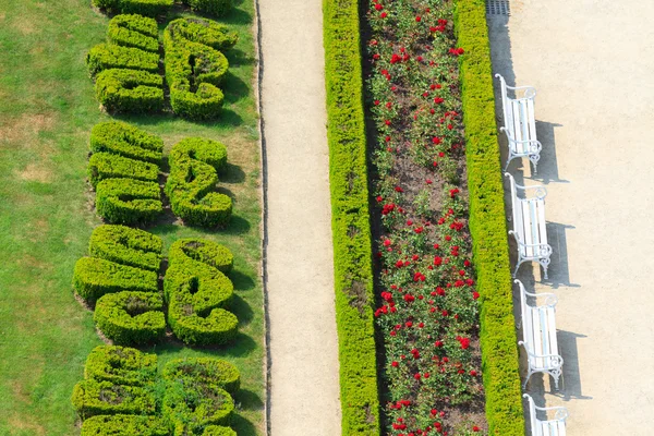 Jardim inglês ornamental com bancos brancos — Fotografia de Stock