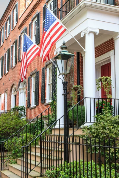 Arquitetura de tijolos coloniais com bandeiras americanas — Fotografia de Stock