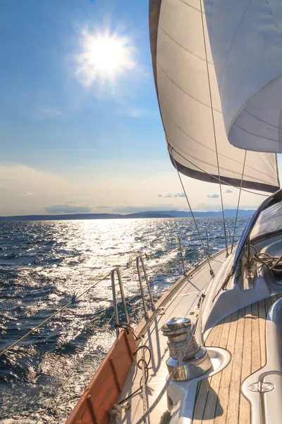 Båten seglar mot solnedgången på blå havet — Stockfoto