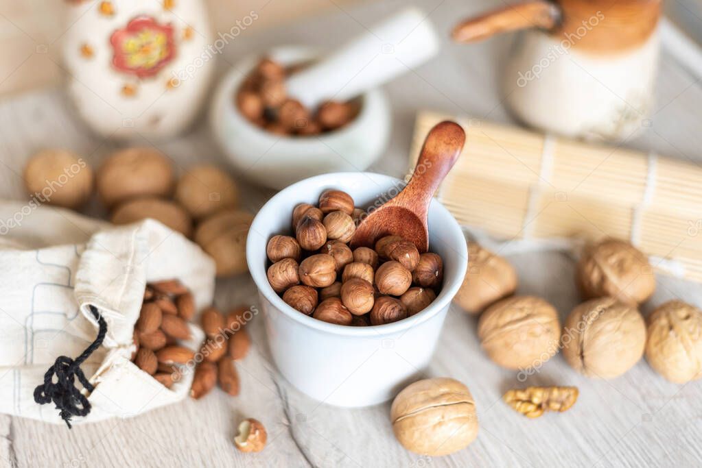 Hazelnuts in a white ceramic bowl, background