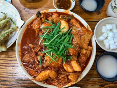 İçinde yeşil ve kırmızı biber, baharatlı sos ve pirinç makarnası var.