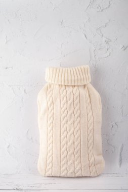 Sıcak su şişesi beyaz örgü örüyor.