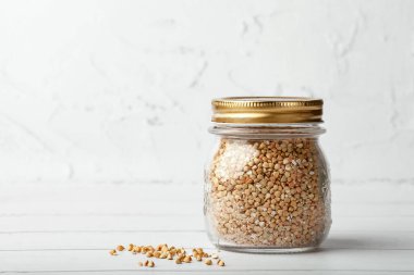 Beyaz masada yeşil karabuğdaylı kavanoz. Metin için boşluk